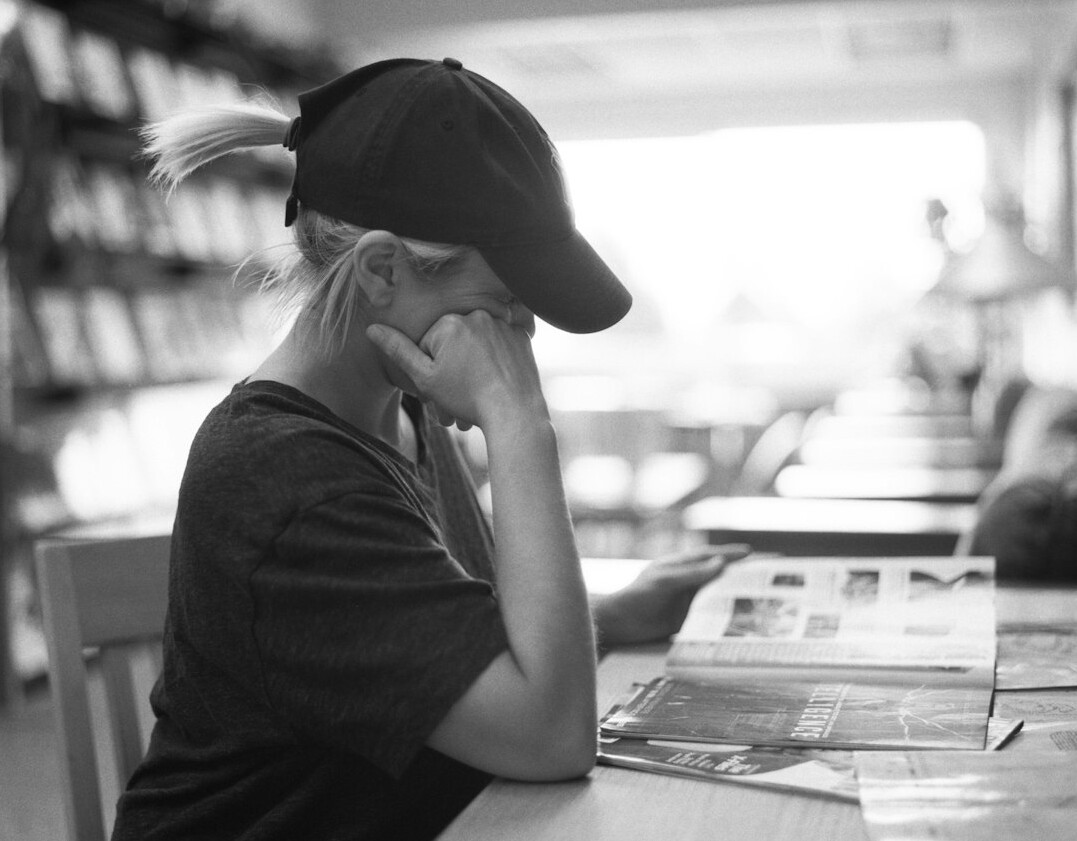 Journalist thinking in a dim newsroom